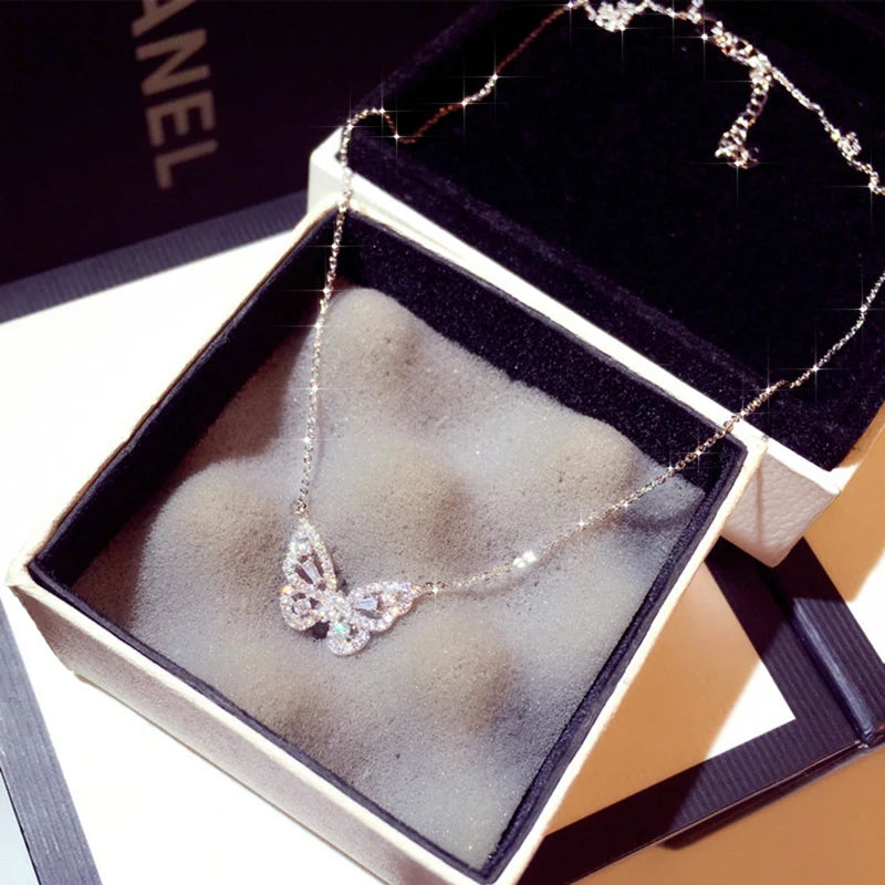 a necklace in a box with a butterfly on it