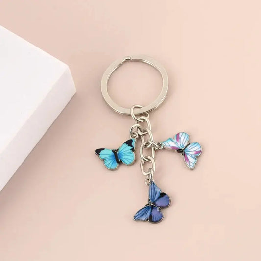 a keychain with three blue butterflies hanging from it