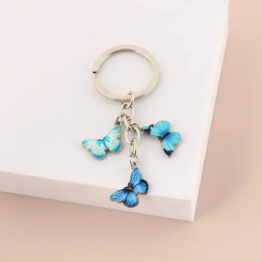a key chain with three blue butterflies hanging from it