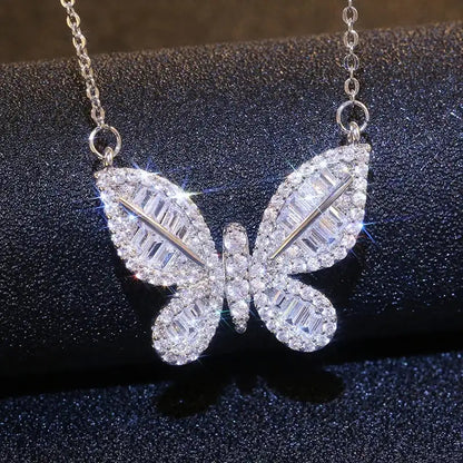 a diamond butterfly necklace on a black surface