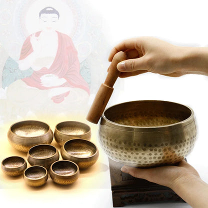 a person is holding a wooden stick over a singing bowl