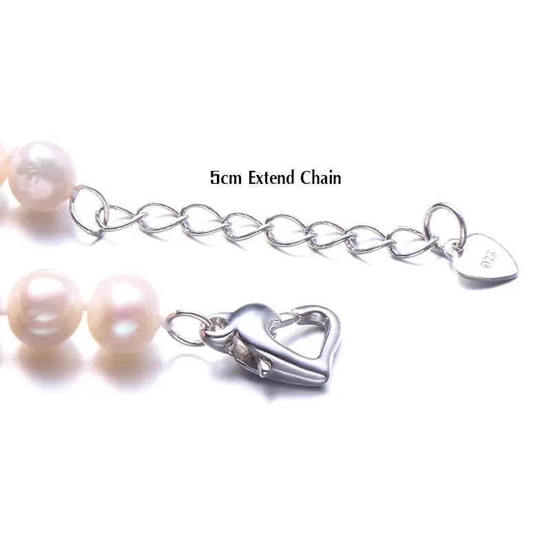 a pair of pearls with a heart charm on a chain