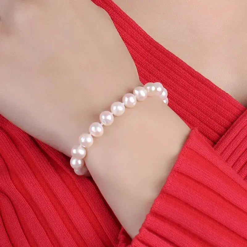 a woman wearing a bracelet with pearls on it