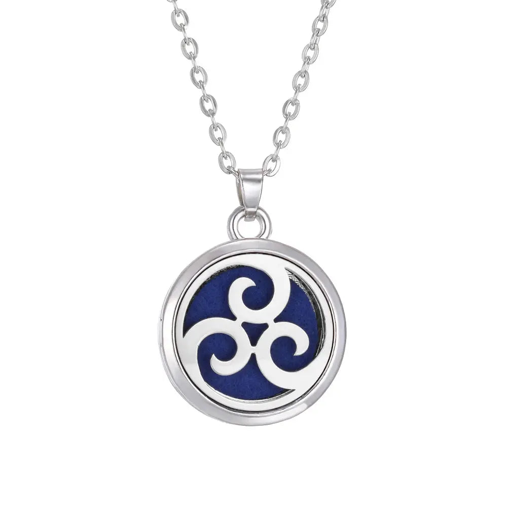 A beautiful Tree of Life stainless steel aroma necklace displayed with essential oil pads for aromatic use - stainless steel aroma necklace
