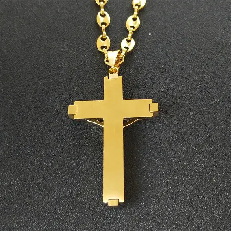 a gold cross necklace on a black surface